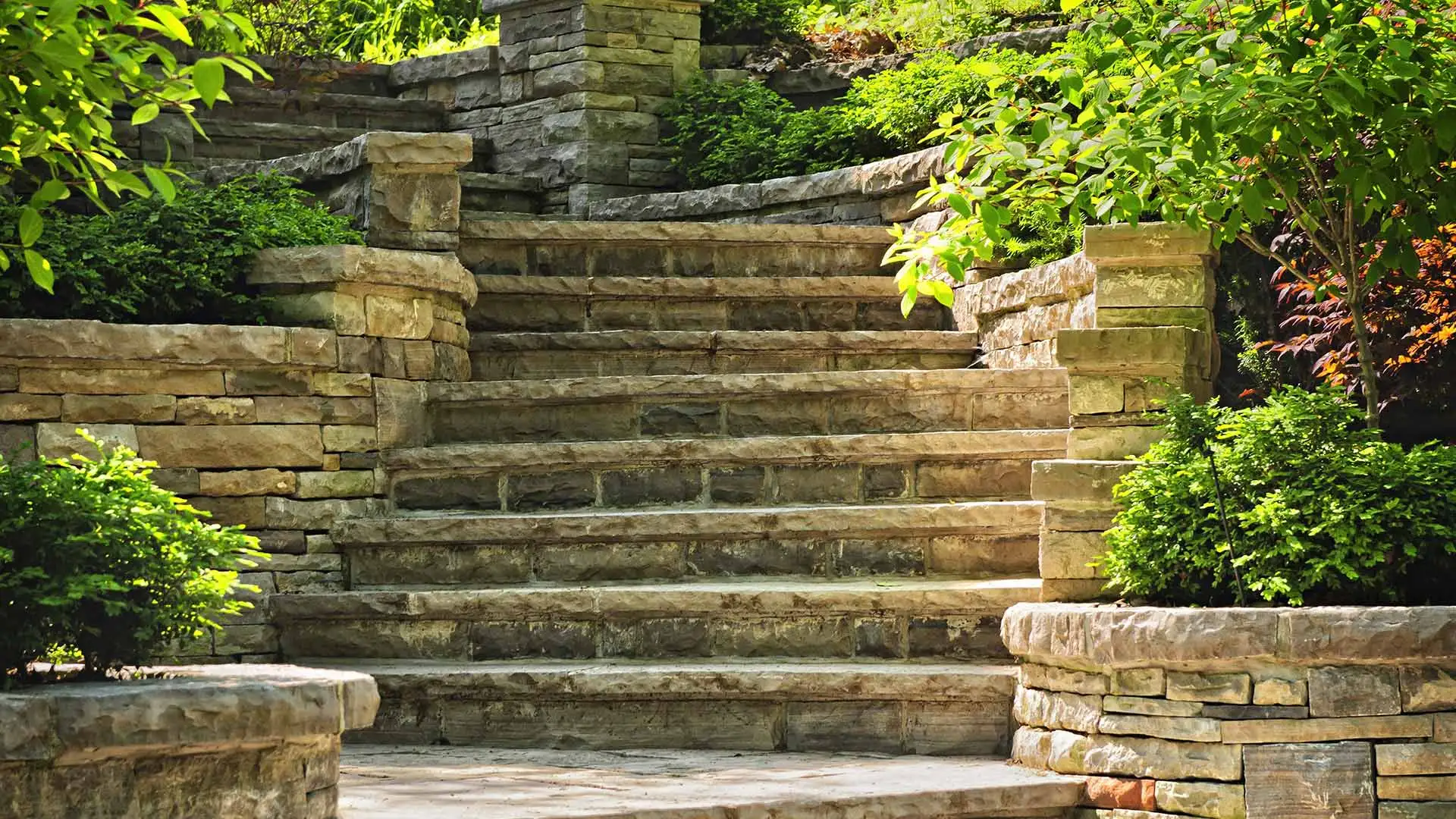 Large stone steps surrounded by landscaping leading up to a home in Greenwood, IN. 