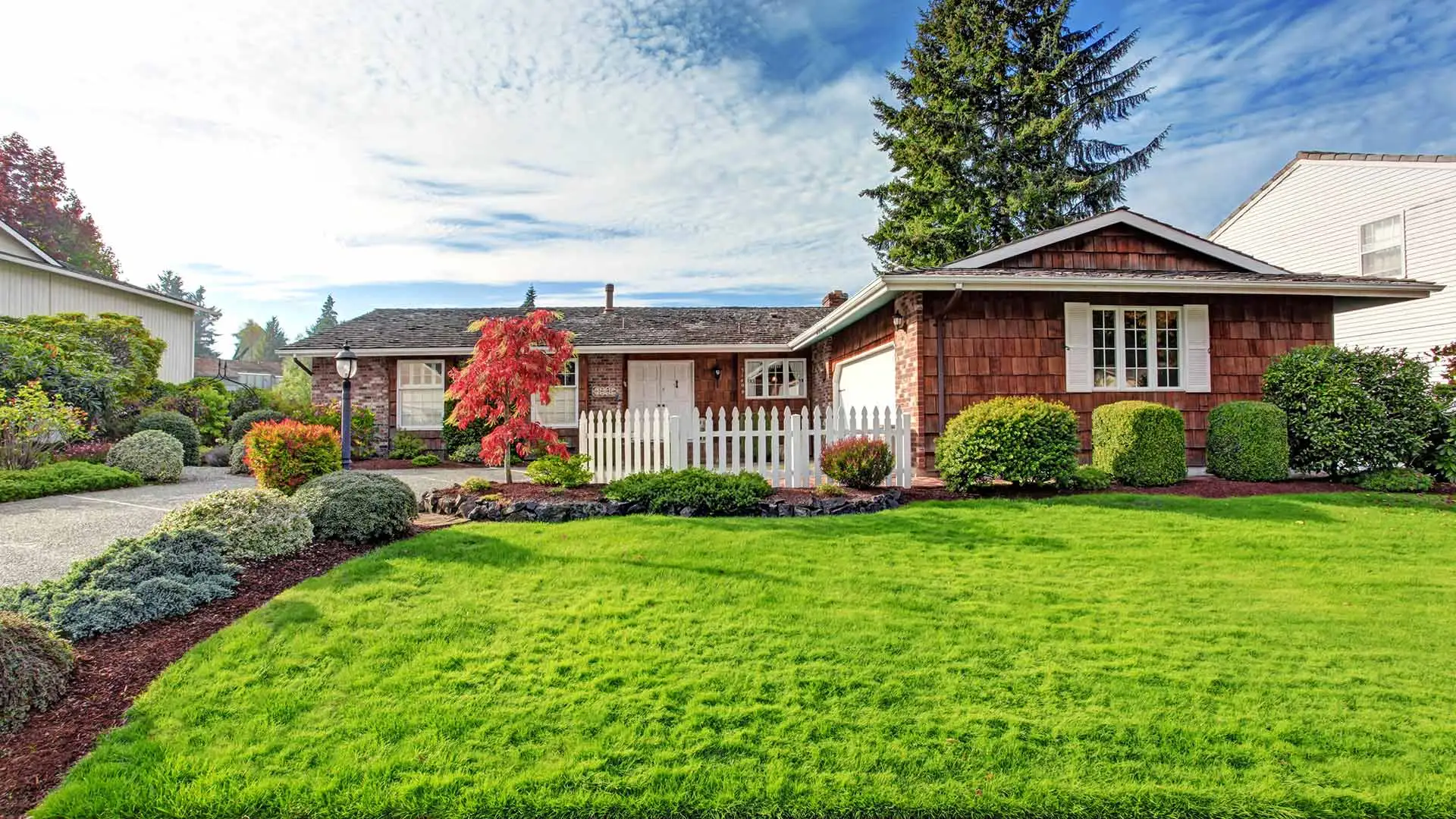 Gorgeous lawn with flawless shrubs and brown wood house in Plainfield, IN.