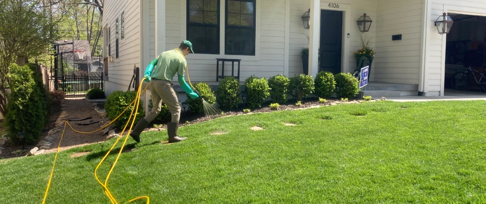 Green Again professional applying pre-emergent weed control to lawn in Lenexa, KS.